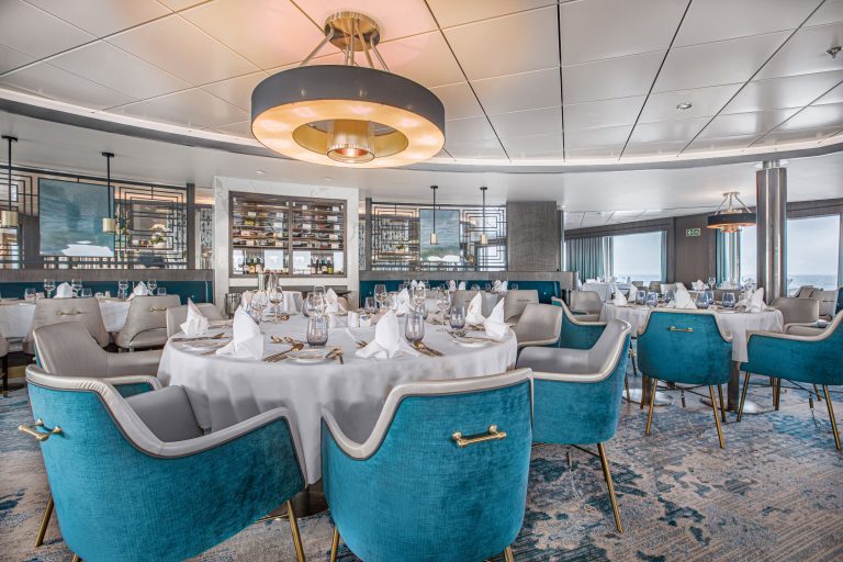 Ocean Victory Beagle Restaurant with circular tables & white tablecloths.