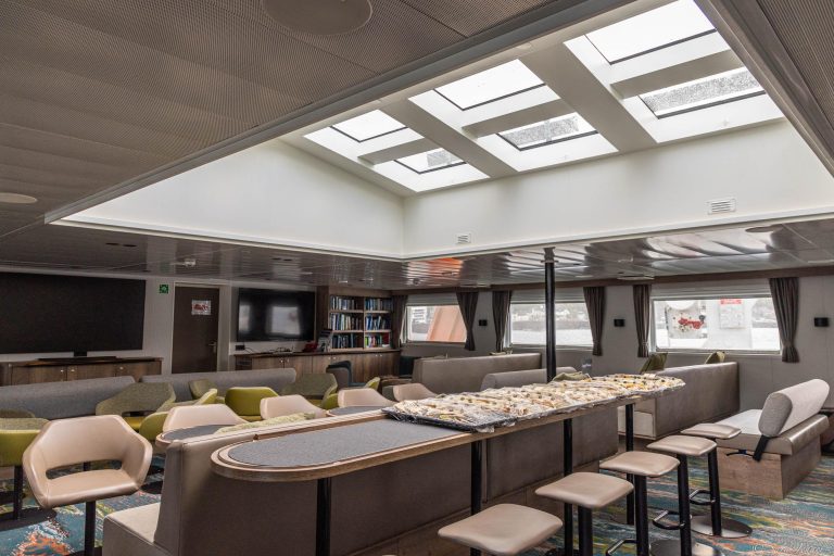 New Observation Lounge on the ship Ortelius showing sylights, chairs, tv, books and large windows